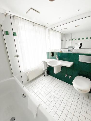 a bathroom with a toilet sink and a mirror at Schlosshotel Kassel in Kassel