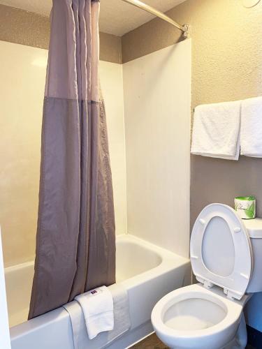 a bathroom with a toilet and a bath tub with a shower curtain at Motel 6-Amarillo, TX - Airport in Amarillo