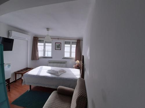una camera da letto con un letto e una sedia di Pensão David, B&B a São Pedro do Sul
