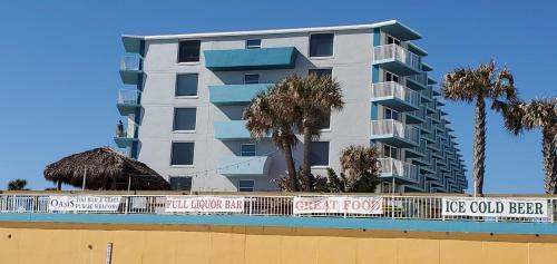 a tall apartment building with palm trees in front of it at Fountain Beach Resort - Daytona Beach in Daytona Beach