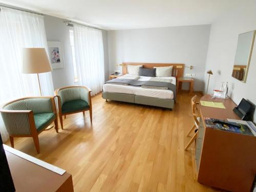 a bedroom with a bed and a table and chairs at Schlosshotel Kassel in Kassel