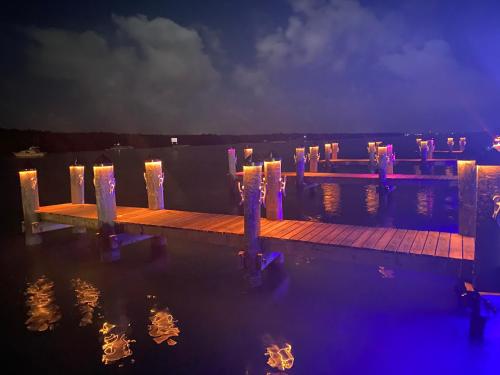 a dock with lit candles in the water at night at Gilbert's Resort in Key Largo