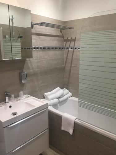 a bathroom with a tub and a sink and a shower at Le Relais Du Lac in Hossegor