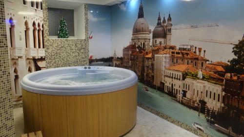 baño con bañera y una foto de la ciudad en Hotel Verona, en Novokuznetsk
