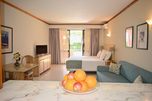 a hotel room with a bed and a bowl of fruit at Clube Oceano Apartments in Albufeira