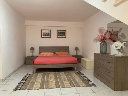 トッレ・デル・オルソにあるVilla Zenのベッドルーム1室(赤いシーツとドレッサー付)
