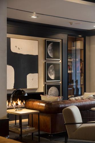 a living room with a leather couch and a fireplace at Casa Elliot Hotel in Barcelona