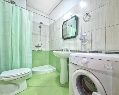 y baño con lavadora y lavamanos. en Allure Apartment, en Sarandë