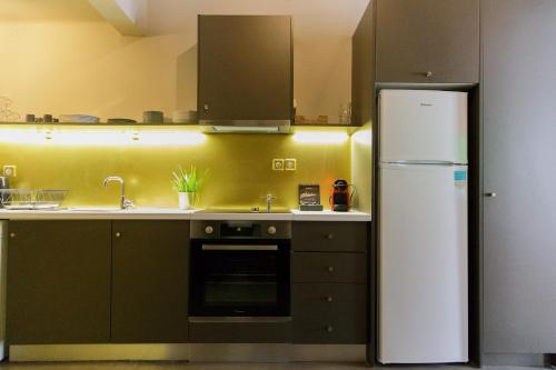Soho Apartments في أثينا: مطبخ مع ثلاجة بيضاء ومغسلة