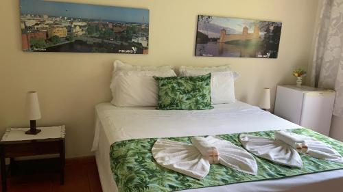 a bedroom with a bed with two dolls on it at Pousada Penedo in Penedo