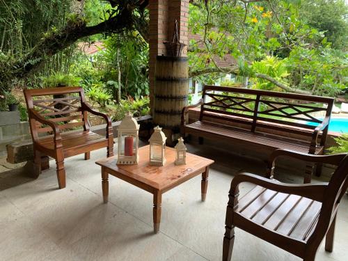 a group of benches and a table and a chair at Pousada Penedo in Penedo