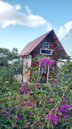 a small church with pink flowers in front of it at Hotel Monte Campana Heredia in Birrí