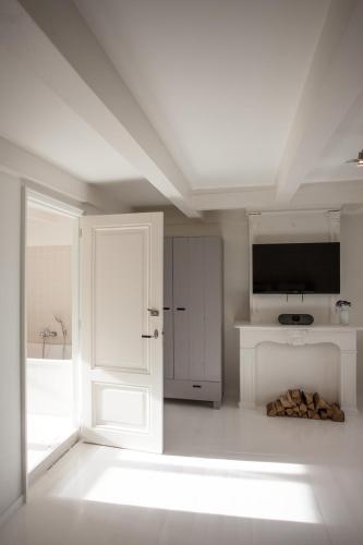 a white room with a door and a television at Mokum Suites in Amsterdam
