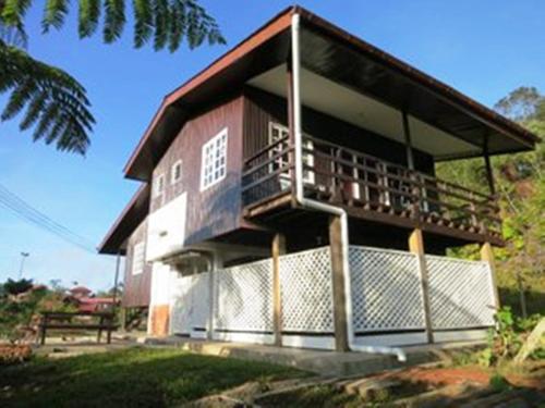 a building with a balcony on the side of it at Mile 36 Lodge in Kundasang