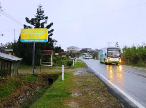 a bus driving down a road with a bus at Mile 36 Lodge in Kundasang