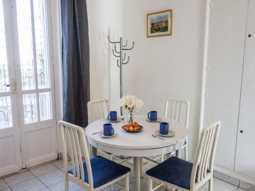 a white table with chairs and a vase of flowers on it at Apartment de la Plage et d'Angleterre by Interhome in Royan