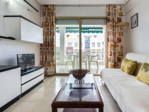 uma sala de estar com um sofá e uma televisão em Apartment Turquesa-1 by Interhome em La Pineda