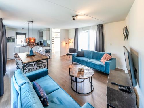 a living room with a blue couch and a table at Holiday Home Citta Romana-1 by Interhome in Hellevoetsluis