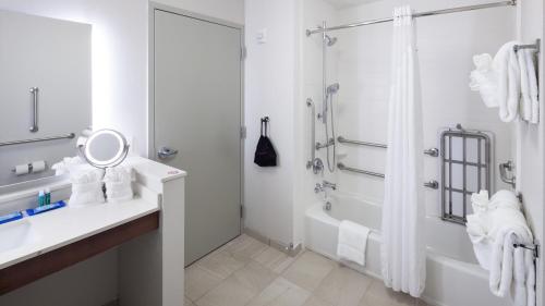 a bathroom with a tub and a sink and a shower at Holiday Inn Express & Suites Orlando At SeaWorld by IHG - With Free Shuttle Service to SeaWorld Parks in Orlando