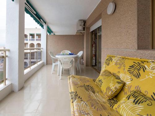 uma sala de estar com um sofá amarelo e uma mesa em Apartment Turquesa-1 by Interhome em La Pineda
