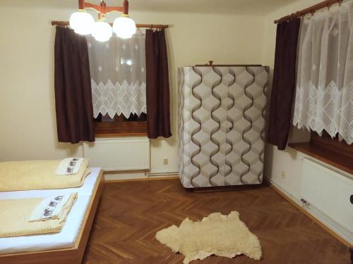 een kamer met een bed en gordijnen en een tapijt bij Apartmán U Zebry in Bílá Třemešná