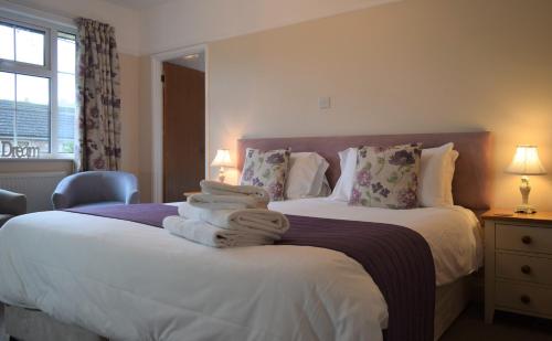 a bedroom with two beds with towels stacked on them at Wye Valley Hotel in Tintern