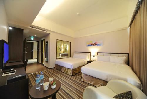 a hotel room with two beds and a television at F Hotel - Hualien - Pet-friendly in Hualien City