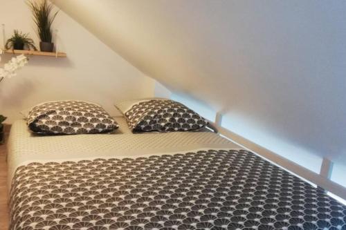 ein Bett mit zwei Kissen darauf in einem Zimmer in der Unterkunft Studio cocooning au pied de la Cathédrale Bayeux in Bayeux