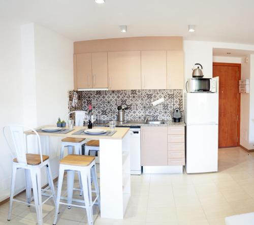 una cocina con electrodomésticos blancos y armarios blancos en Mataro Luxury Apartments, en Mataró