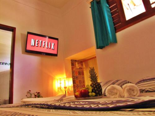 a sign on a wall with fruit on a bed at Residencial Bem-te-vi in Jericoacoara