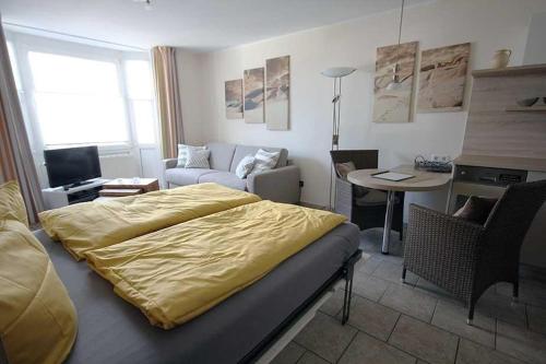 um quarto com uma cama e uma sala de estar em Ferienwohnung-40-in-der-Residenz-Meeresbrandung-mit-Strandkorb em Cuxhaven