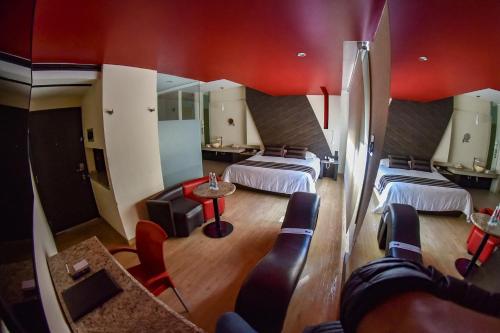 a room with three beds and a table and chairs at La Moraleja Love hotel in Mexico City