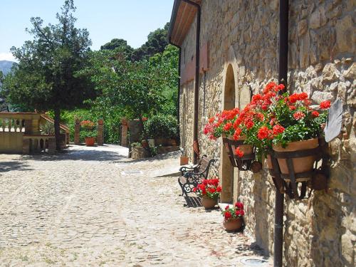a stone building with flower pots and flowers on it at SESIMA turismo rurale in Mistretta