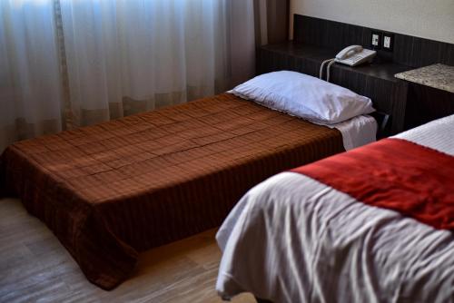 a hotel room with two beds and a phone at La Moraleja Love hotel in Mexico City
