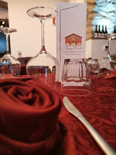 a table topped with glasses and a wine glass at SESIMA turismo rurale in Mistretta