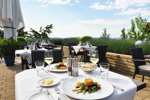 a table with plates of food and glasses of wine at Hotel Rebenhof in Baden-Baden