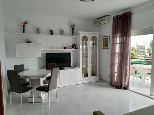 a living room with a table and a tv at Casa Sardinero in Torremolinos