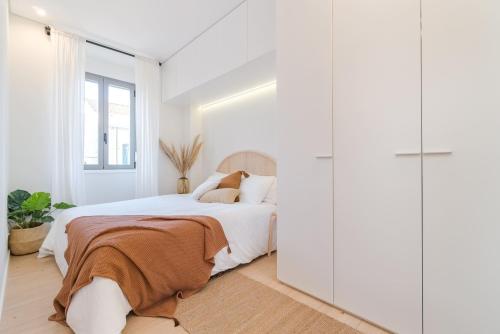 Dormitorio blanco con cama y armario en Casa Boma Lisboa - Modern & Luminous Apartment with Balcony - Alcantara I, en Lisboa