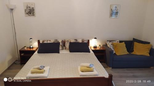 ein Schlafzimmer mit einem großen Bett und einem blauen Sofa in der Unterkunft Studio apartment Marčelina in Preko