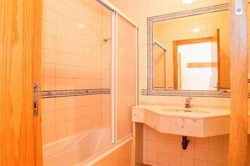 a bathroom with a sink and a shower and a mirror at Veleiro Verde in Monte Gordo