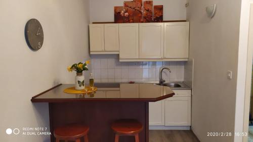 eine Küche mit weißen Schränken und einer Theke mit Stühlen in der Unterkunft Studio apartment Marčelina in Preko