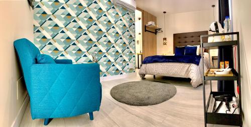 a bedroom with a blue chair and a bed at La Macarena Airport in Málaga