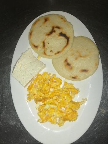 a plate of food with eggs and toast and cheese at Manzanillo Beach in Cartagena de Indias