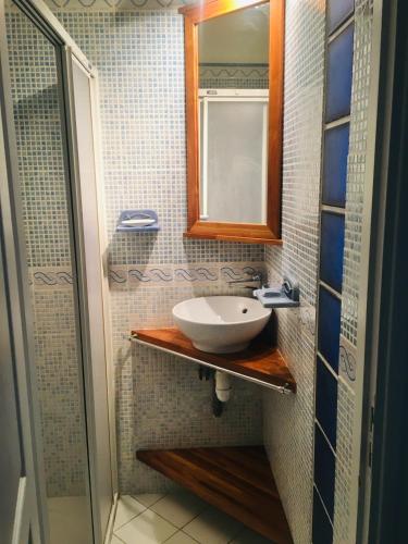 une salle de bain avec un lavabo et un miroir dans l'établissement Cocon sur mer, à Varengeville-sur-Mer