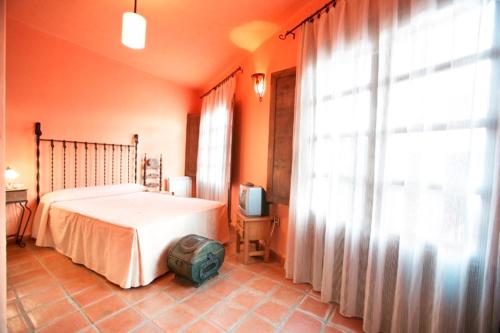 1 dormitorio con 1 cama, TV y ventana en Casa Rural Las Gamellas, en Rebollar