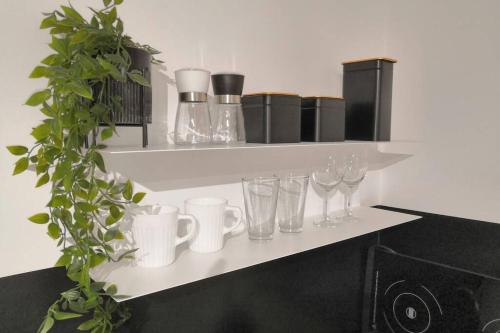 a shelf with wine glasses and a plant on it at OficynaApartments in Gliwice