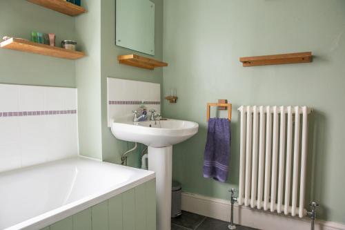 a bathroom with a sink and a radiator at I'm Your Host - Westcotes Stay in Leicester