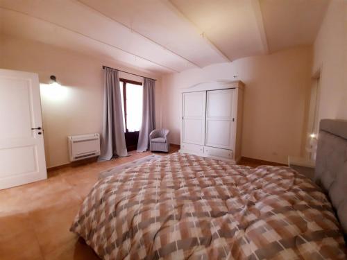 Un dormitorio con una cama grande y una ventana. en Mignola Le Bozze- Podere con piscina-WI-FI, en Castagneto Carducci