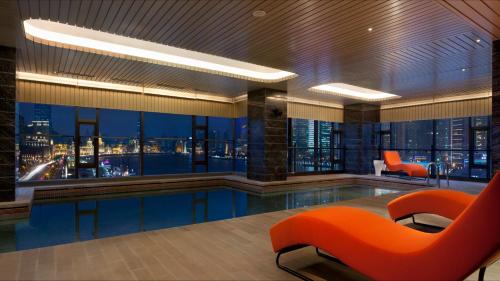 a hotel lobby with a pool with a view of the city at Hotel Indigo Shanghai On The Bund, an IHG Hotel in Shanghai