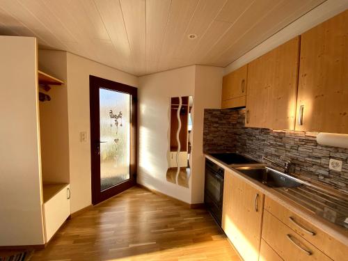 een keuken met een wastafel en een raam erin bij Verträumt schön zu jeder Jahreszeit Bergpanoramasicht in Albinen